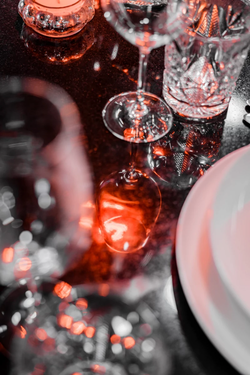 Elegant gedeckter Tisch mit Gläsern und Kerzenlicht in Eventküche.