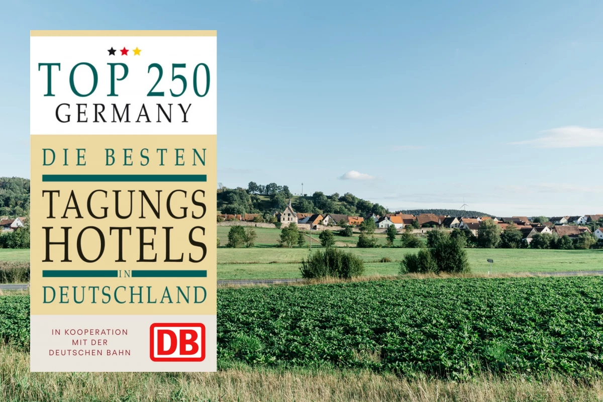 Top 250 Deutschland Magazin über die besten Tagungshotels, links daneben eine grüne Landschaft mit Feldern und Häusern im Hintergrund, herausgegeben in Kooperation mit der Deutschen Bahn.