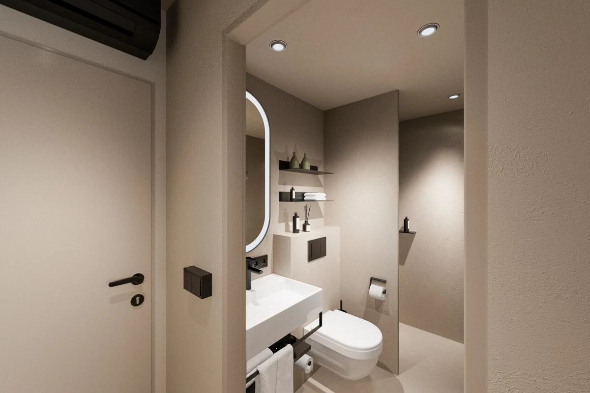 Modernes, minimalistisches Hotelzimmer-Badezimmer in hellen Beige- und Weißtönen. Ausgestattet mit einem weißen Waschbecken, Spiegel, Toilette und eingebauten Wandregalen. Dezente Beleuchtung durch Deckenspots sorgt für eine warme, einladende Atmosphäre.