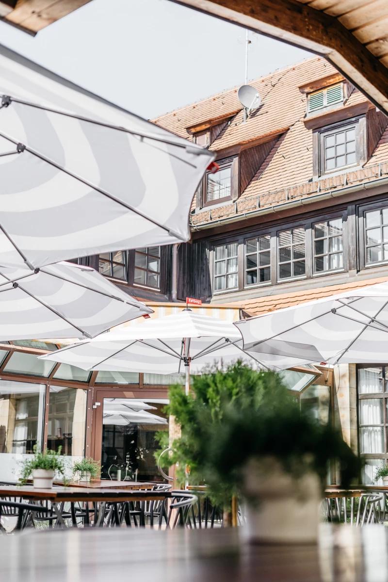 Hotel Riesengebirge Außenbereich mit Sonnenschirmen und gemütlicher Terrasse.